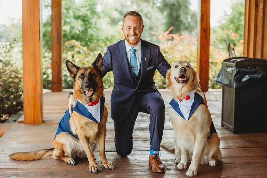 A man in a suit with two large dogs
